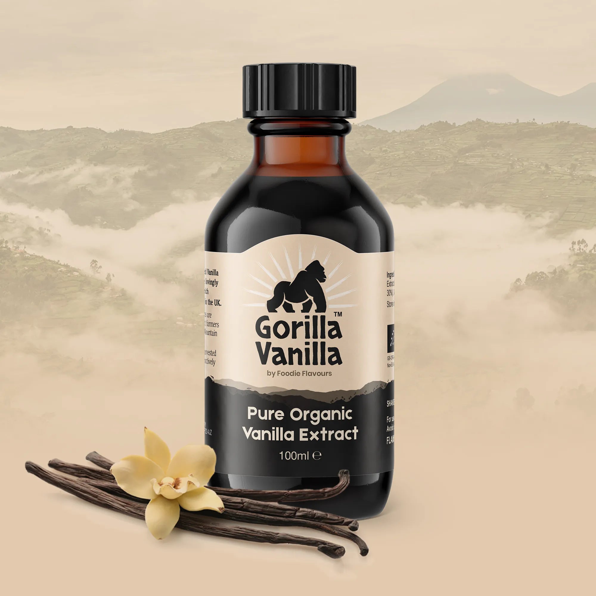 Glass bottle of Gorilla Vanilla, organic vanilla extract with a vanilla flower and pods. In the background are the Ugandan mountains.