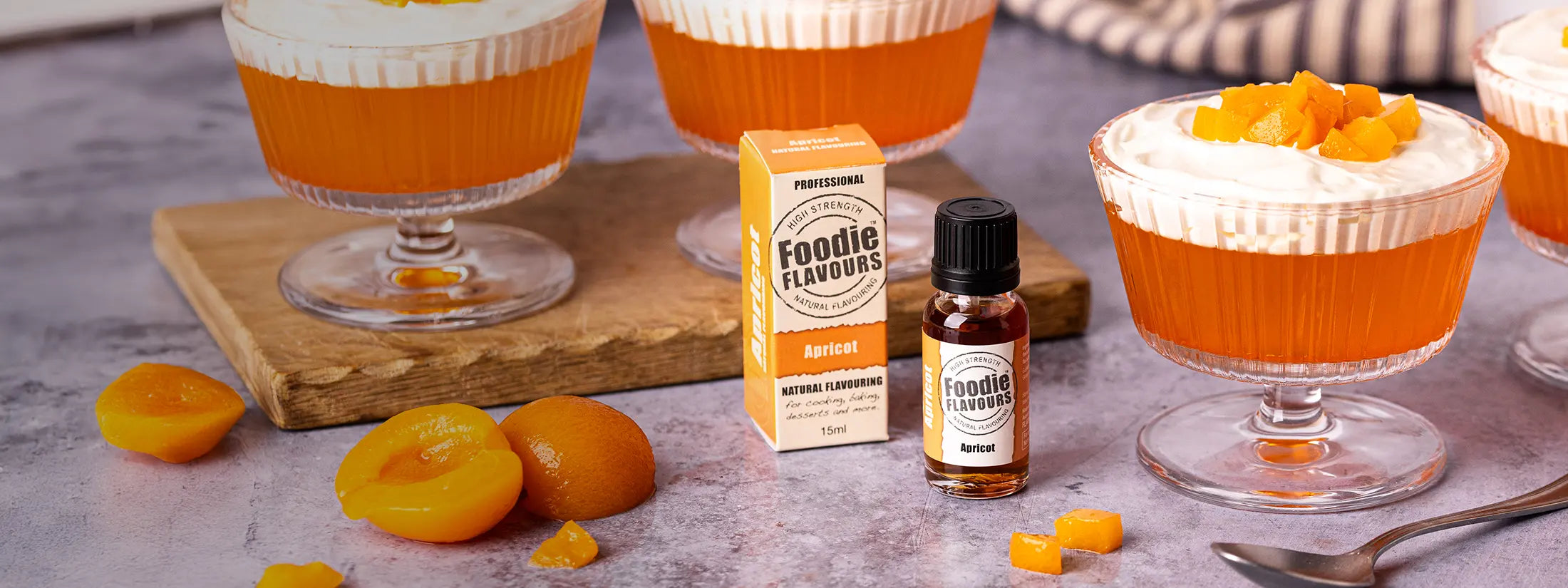 Apricot natural flavouring bottle, apricot flavoured jelly in dessert glasses