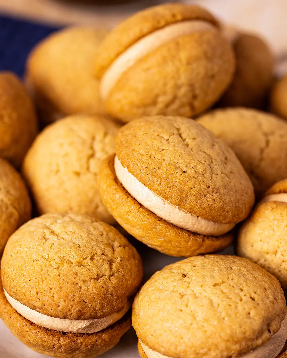 Close-up of coffee kisses sandwich cookies with cream filling on a white plate