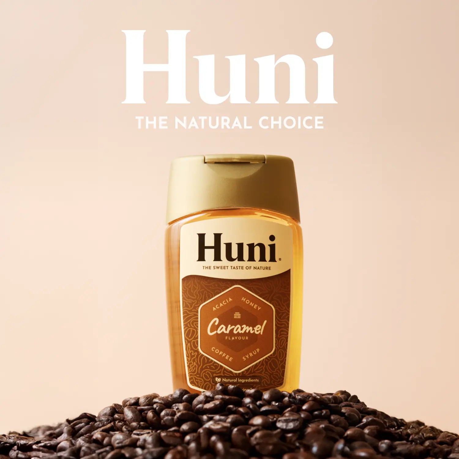 Huni caramel coffee syrup bottle with coffee beans on a beige background