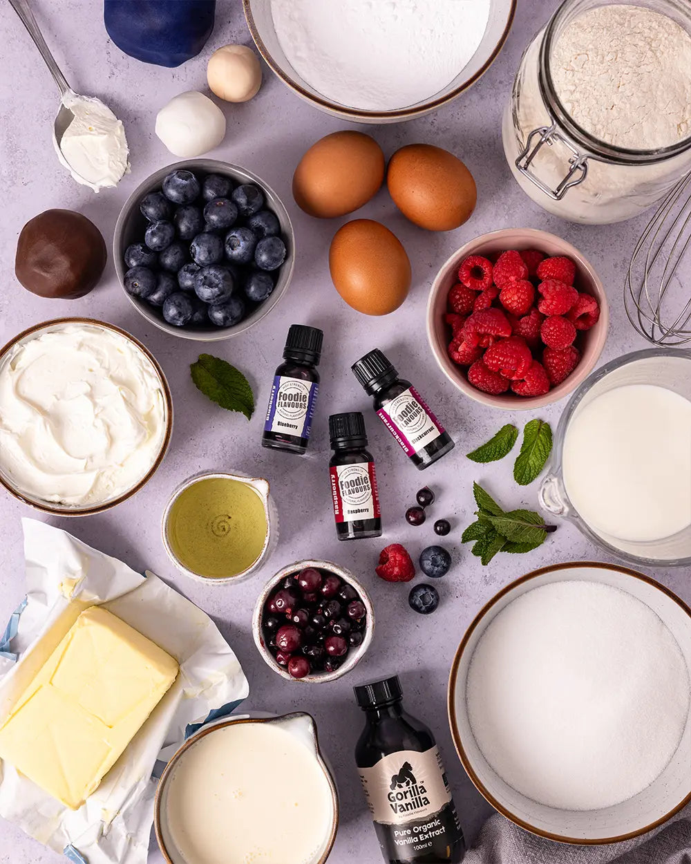 Ingredients for a Layered cake with berries. Vanilla extract and three bottles of natural flavouring, blueberry, raspberry and blackcurrant