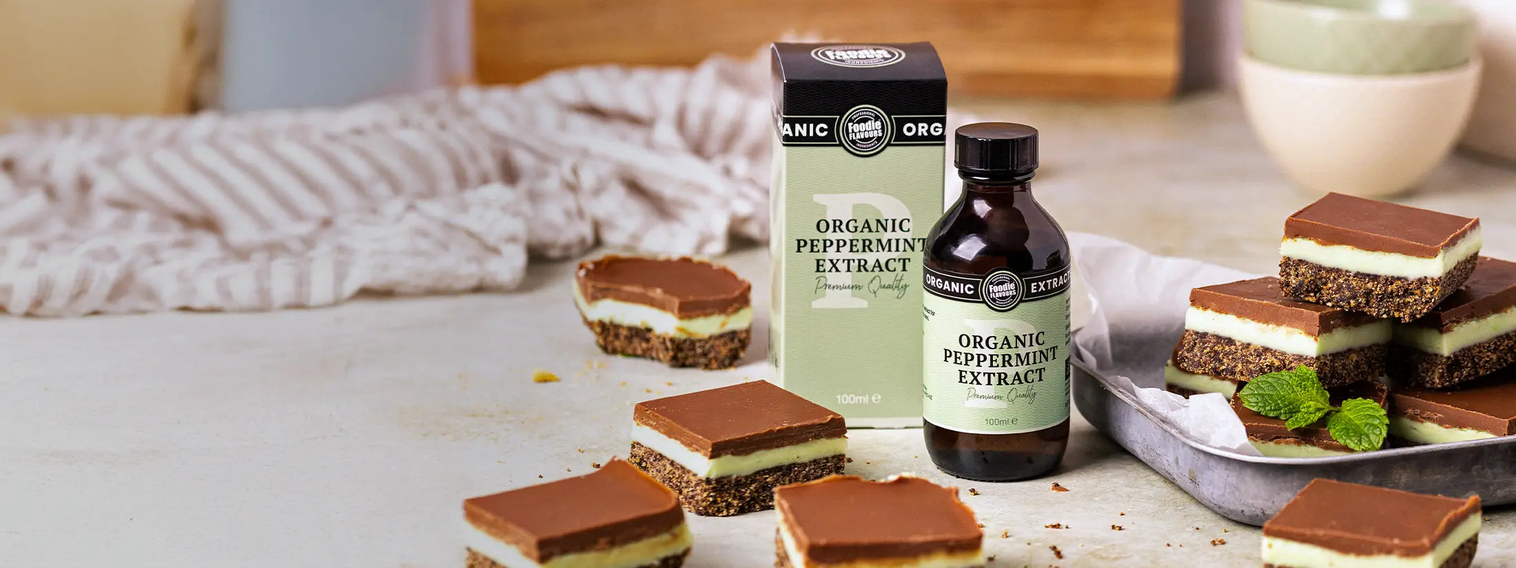 Organic peppermint extract bottle with chocolate mint slices on a wooden surface