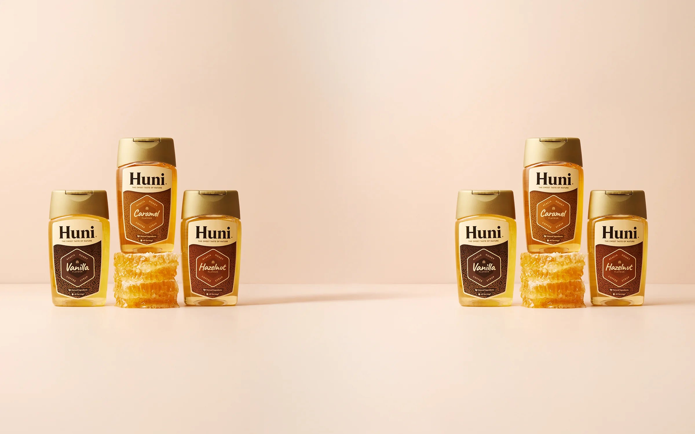 Row of Huni coffee syrup bottles on a beige background