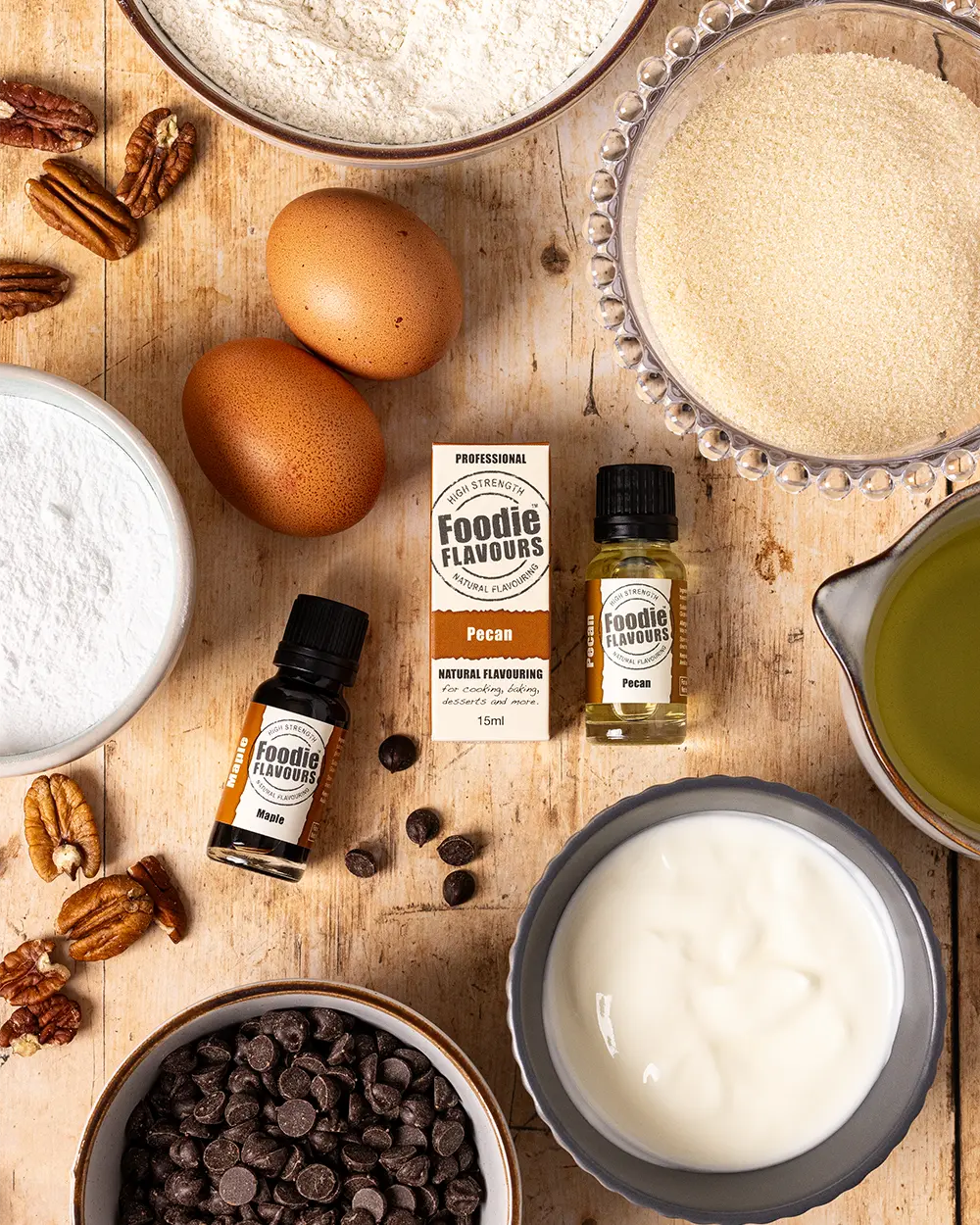 Baking ingredients and Foodie Flavours pecan and maple essences on a wooden surface
