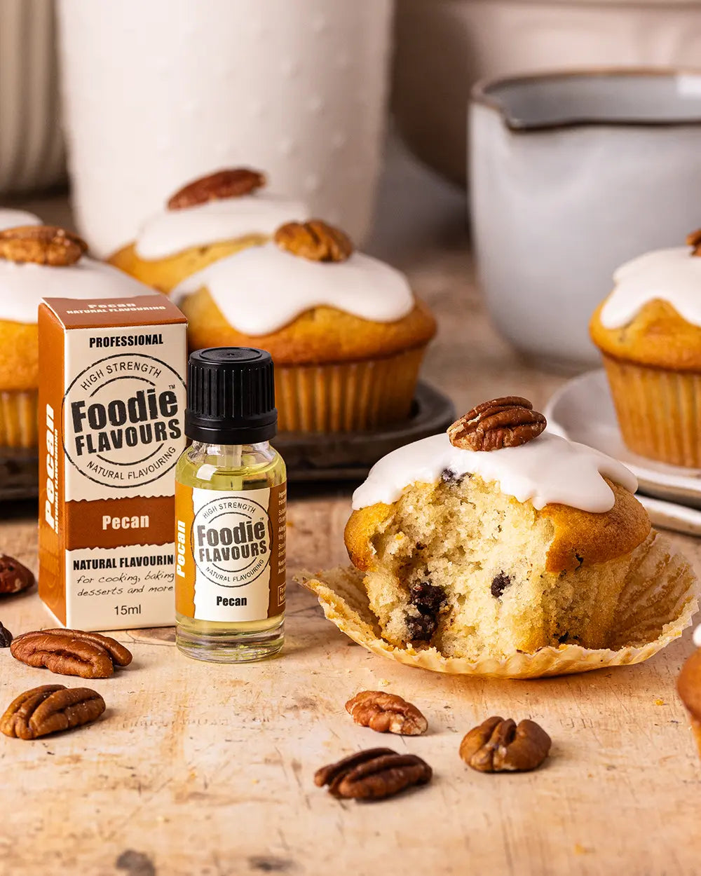Pecan muffin with a Foodie Flavours pecan flavouring bottle and packaging on a wooden surface.