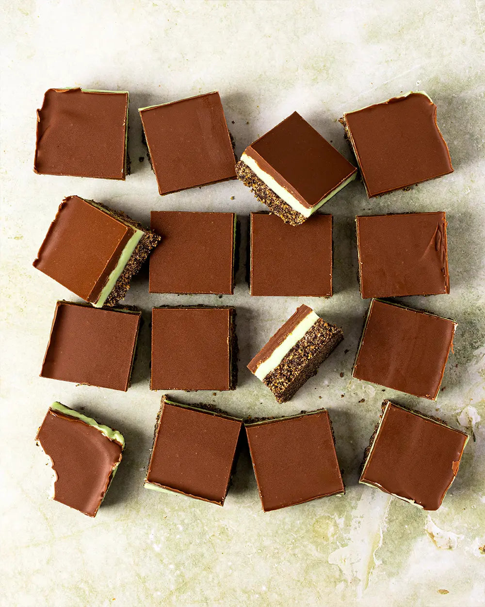 Chocolate peppermint square treats on a textured surface