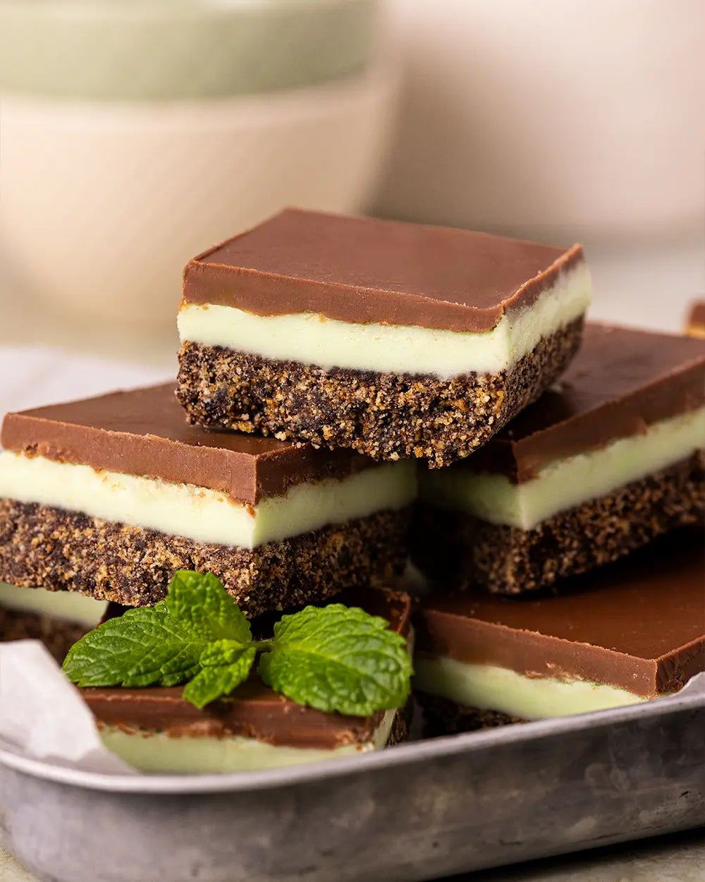 Stack of chocolate mint slices on a plate with a blurred background